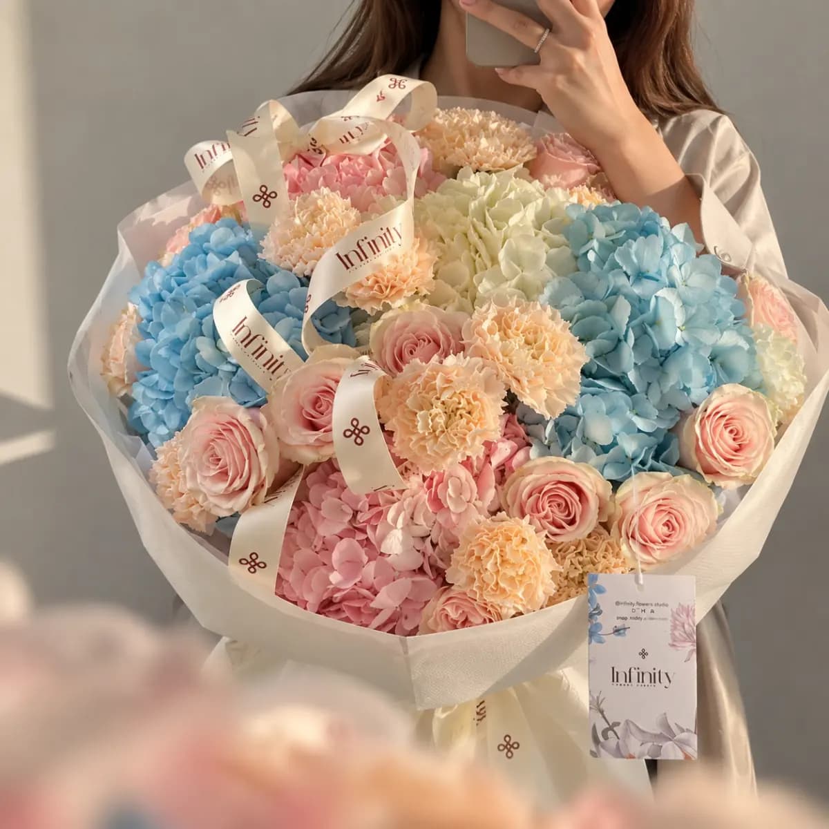 Infinity bouquet of blue and pink hydrangeas with roses and carnations
